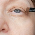 Middle-aged woman does corrective eye makeup to correct the drooping eyelid. Ptosis is a drooping of the upper eyelid, lazy eye. Royalty Free Stock Photo