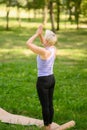Middle-aged woman doing yoga outdoors in the park in Tadasana pose.Mountain Pose. Samasthiti.Back view Royalty Free Stock Photo
