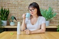 Middle aged woman drinking fermented milk product from bottle