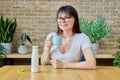 Middle aged woman drinking fermented milk product from bottle