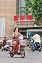 Middle-aged woman on e-bike in city center, Nanjing, China