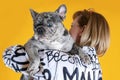 Middle aged woman embracing beautiful young French Bulldog of unusual grey merle spotted color.