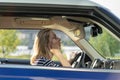 Middle aged woman fix makeup looking in rear view mirror drive car. Female driver distract from road Royalty Free Stock Photo