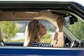 Middle aged woman fix makeup looking in rear view mirror drive car. Female driver distract from road Royalty Free Stock Photo