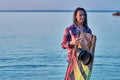 A middle-aged woman has finished wakesurfing on a big river on a summer evening