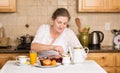 Middle aged woman having breakfast in a kitchen Royalty Free Stock Photo