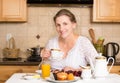 Middle aged woman having breakfast in a kitchen Royalty Free Stock Photo