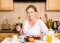 Middle aged woman having breakfast in a kitchen Royalty Free Stock Photo