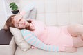 Tired middle age woman lying on sofa at home background with headache and depression. Menopause. Copy space and summer time Royalty Free Stock Photo