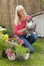 Middle aged woman with her cat in her garden Royalty Free Stock Photo