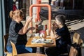 A middle aged woman and her elderly mother talking whilst having a coffee in a coffee shop