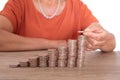 Middle-aged woman holding coins in hand to continue stacking growing dollar coins
