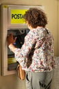 Middle-aged woman woman inserting credit card at ATM