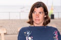 Middle-aged woman look aside into the distance while sitting on a summer terrace cafe beach Royalty Free Stock Photo