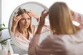 Middle Aged Woman Looking In Mirror And Touching Wrinkles On Her Face Royalty Free Stock Photo