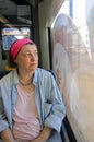 Middle-Aged Woman Looks Seriously Out of the Window in a German Tram