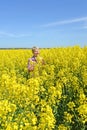 Middle-aged woman loves blooming rapeseed in field