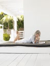 Middle Aged Woman Lying On Daybed On Verandah