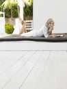 Middle Aged Woman Lying On Daybed On Verandah