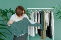 Middle aged woman shopping new dress clothes shelf green Royalty Free Stock Photo