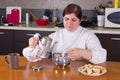 Middle-aged woman making tea in kitchen