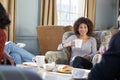 Middle Aged Woman Meeting Friends Around Table In Coffee Shop