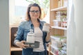 Middle-aged woman picking food from storage cabinet in kitchen Royalty Free Stock Photo