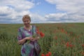 Middle-aged woman on a poppy field Royalty Free Stock Photo