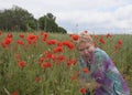 A middle-aged woman on a poppy field Royalty Free Stock Photo