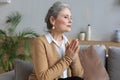 Middle aged woman praying, eyes closed, looking up, hoping for best, asking for forgiveness Royalty Free Stock Photo