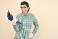 Middle-aged woman with protective gloves and glasses holding electric drill Royalty Free Stock Photo