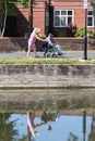 A middle aged woman pushing an elderly man in a wheelchair