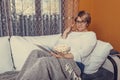 Middle aged woman reading book and eating popcorn Royalty Free Stock Photo