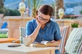 Middle aged woman reading book on an outdoor armchair Royalty Free Stock Photo