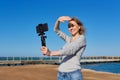 Middle-aged woman recording video on smartphone with outdoor on seashore Royalty Free Stock Photo