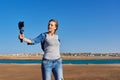 Middle-aged woman recording video on smartphone with outdoor on seashore Royalty Free Stock Photo