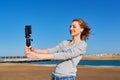 Middle-aged woman recording video on smartphone with outdoor on seashore Royalty Free Stock Photo