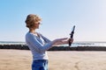 Middle-aged woman recording video on smartphone with outdoor on seashore Royalty Free Stock Photo