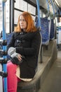 A middle-aged woman with red hair sits on a seat while riding a bus Royalty Free Stock Photo