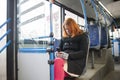 A middle-aged woman with red hair sits on a seat while riding a bus Royalty Free Stock Photo