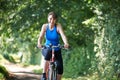 Middle Aged Woman Riding Bike Through Countryside