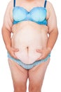 Middle aged woman with sagging skin after babies and extreme weight loss. Front view holding excess belly skin. Royalty Free Stock Photo