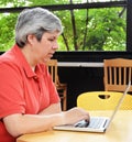 Middle-aged woman seated browsing on laptop