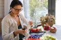 A middle-aged woman sews homemade dolls