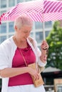 middle-aged woman with a short haircut with an umbrella protecting from sun Royalty Free Stock Photo