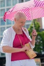 middle-aged woman with a short haircut with an umbrella protecting from sun Royalty Free Stock Photo