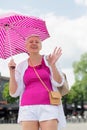 middle-aged woman with a short haircut with an umbrella protecting from sun Royalty Free Stock Photo