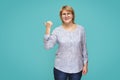 A woman in a blouse and jeans stands on a blue green background Royalty Free Stock Photo