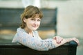 Middle-aged woman sits on a bench in a public garden Royalty Free Stock Photo