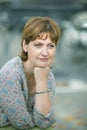 Middle-aged woman sits on a bench in a public garden Royalty Free Stock Photo